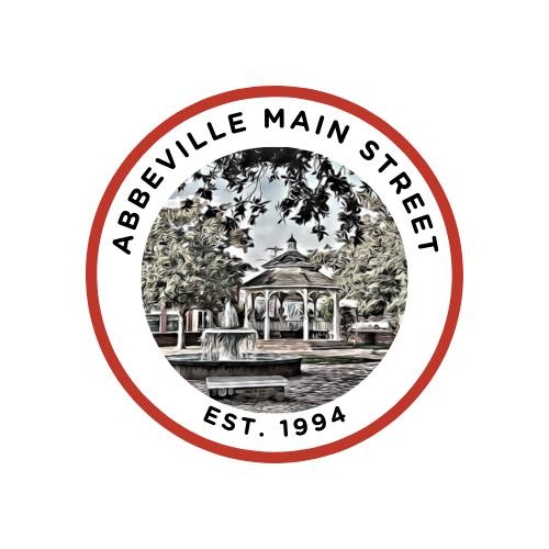 Circular Abbeville Main Street logo featuring a stylized illustration of Magdalen Square’s gazebo and fountain, surrounded by the text “Abbeville Main Street – Est. 1994.”